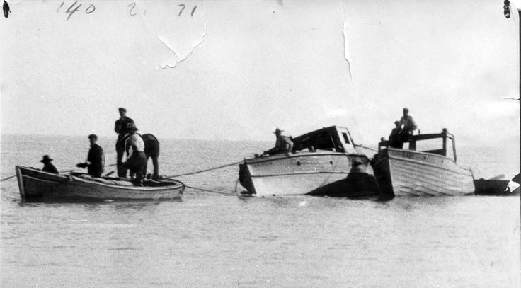 Photograph of men salvaging whiskey from rum-running vessel that had hit a sandbar, near Leamington, ONT